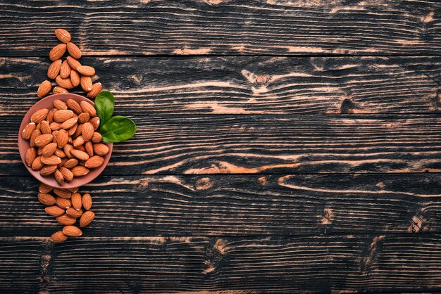 Nueces de almendras sobre un fondo de madera oscura. Aperitivos saludables. Vista superior. Espacio libre para texto.