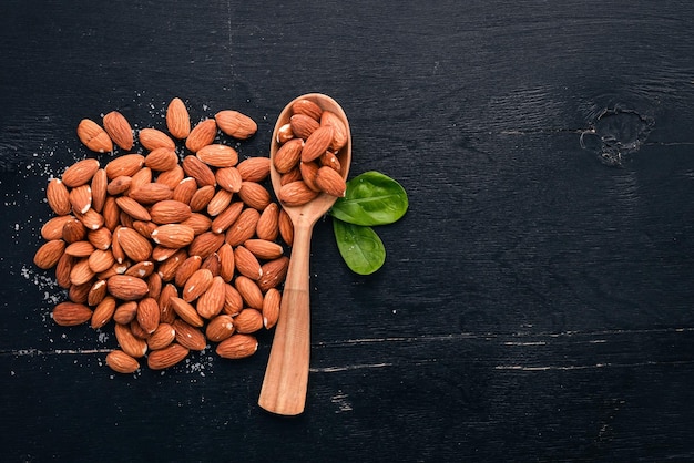 Nueces de almendras sobre un fondo de madera oscura Aperitivos saludables Vista superior Espacio libre para texto