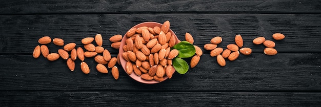 Nueces de almendras sobre un fondo de madera oscura Aperitivos saludables Vista superior Espacio libre para texto