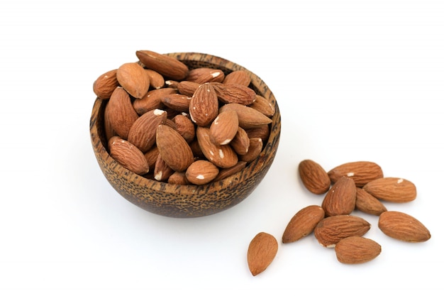 Nueces almendras en un tazón marrón sobre un blanco