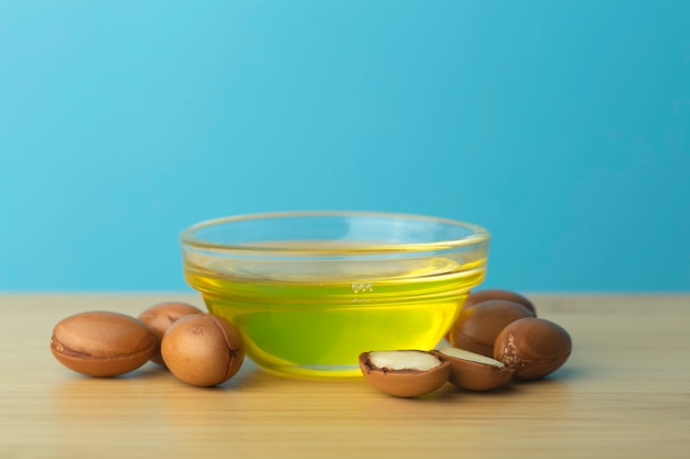 Foto nueces de argán y aceite en una mesa de madera