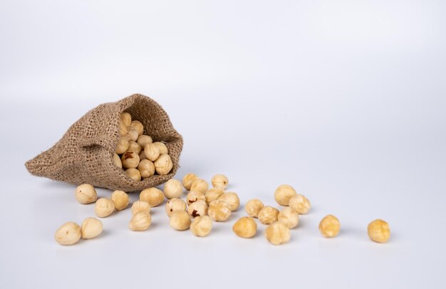 Foto nueces de avellana en saco derramado aislado en un fondo blanco. copie el espacio, vacío.