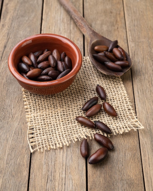 Nueces de barú brasileñas en un recipiente sobre una mesa de madera