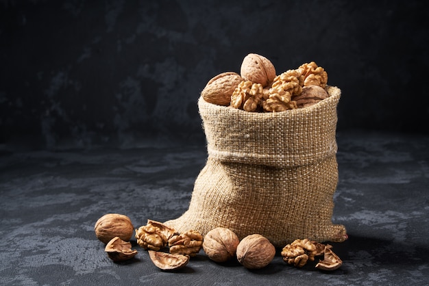 Nueces en bolsa en mesa negra. Montón o pila de nueces.