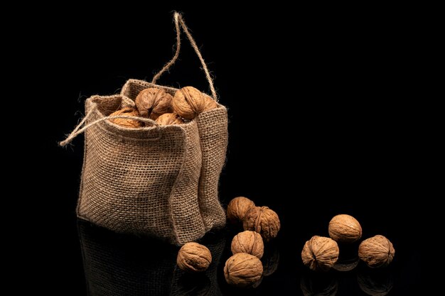 Foto nueces en la bolsa sobre un fondo negro.