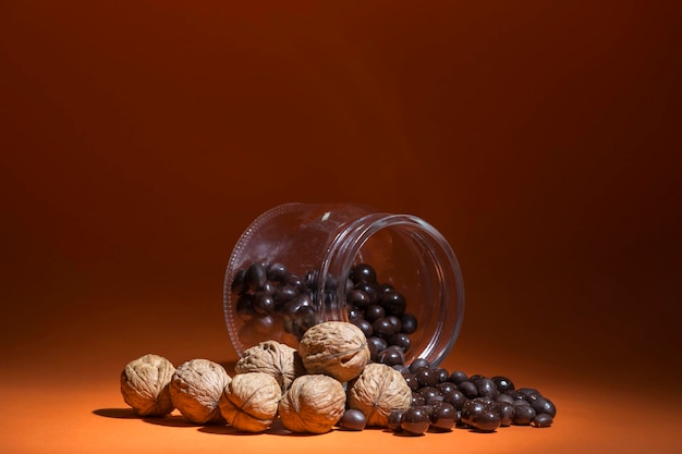 Nueces y bombones de chocolate derramados de un tarro de cristal