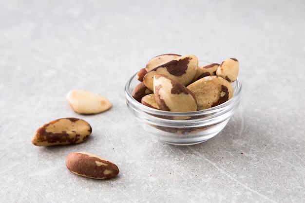 Nueces de Brasil en el bol de vidrio en la tabla de piedra.