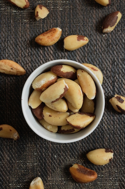 Nueces brasileñas en un recipiente sobre una mesa de madera.