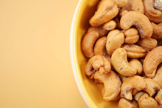 Nueces de caju en un cuenco pequeño sobre un fondo de color amarillo