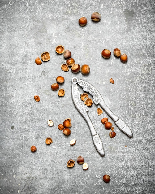 Nueces con un cascanueces. Sobre la mesa de piedra.