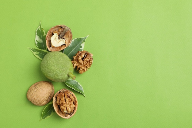 Nueces con cáscara de nuez sobre fondo verde