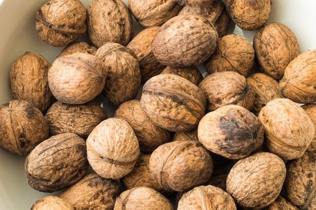 Nueces en cáscara sobre un fondo blanco