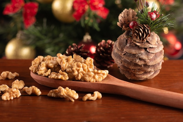 Nueces en una cuchara de madera sobre un fondo de Navidad