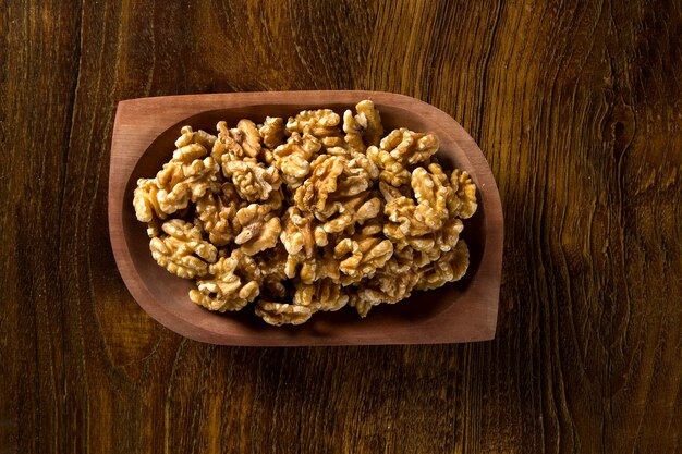 nueces en cuenco de madera sobre mesa de madera.