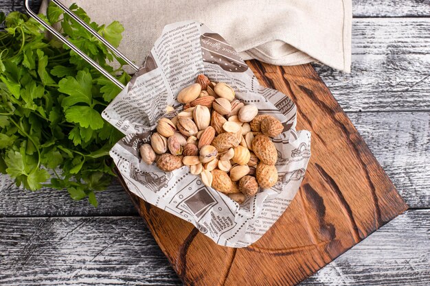 Nueces diferentes nueces para cerveza sobre un fondo blanco de madera