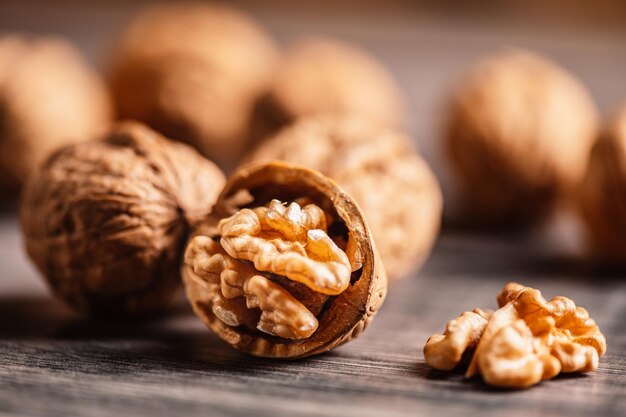 Nueces enteras y abiertas con grano de nuez en una mesa de madera