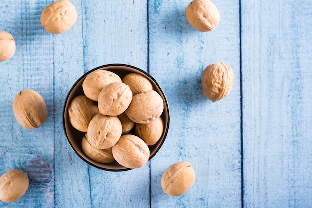 Nueces enteras maduras con cáscara en un recipiente sobre la mesa Alimentos orgánicos Vista superior