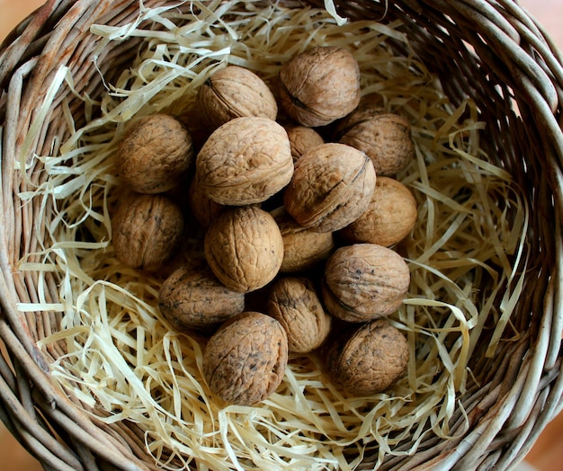 Nueces enteras, montón, en, un, virutas de madera, dentro, mimbre, bandeja, detallado Colección de foto