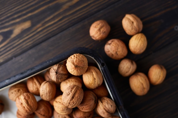 Nueces enteras naturales en la mesa de madera oscura Vista superior plana con espacio de copia