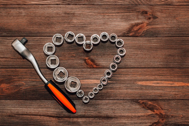 Nueces a una llave inglesa, un conjunto de herramientas en forma de corazón. Regalo de San Valentín para un hombre.