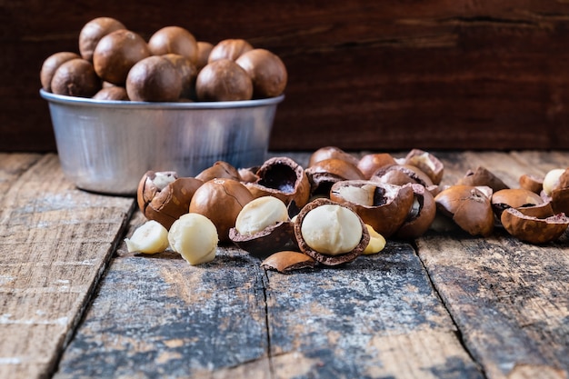 Foto nueces de macadamia con conchas en un bol.