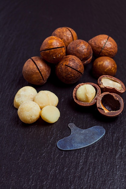 Nueces de macadamia orgánicas en primer plano de fondo de pizarra negra