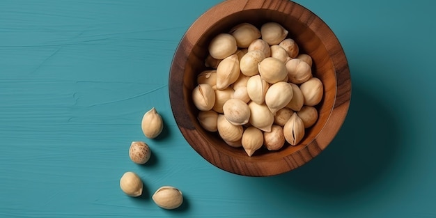 Nueces de macadamia peladas en cuenco de madera sobre fondo azul.