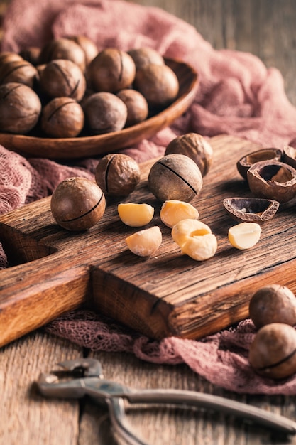 Nueces de macadamia en tabla de cortar sobre mesa de madera