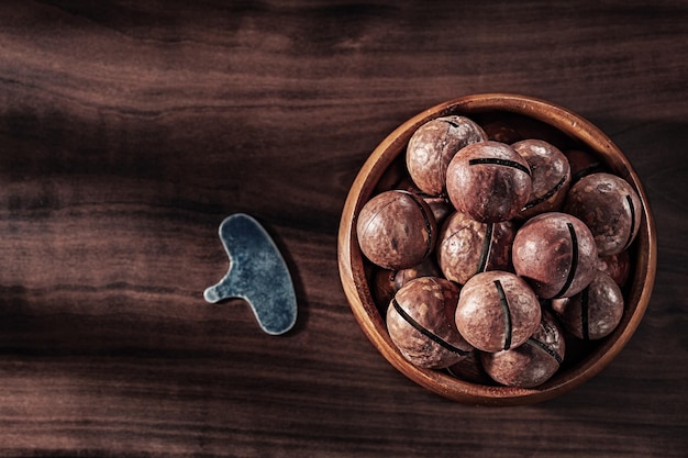 Nueces De Macadamia En Tazón De Madera Clave Para Abrir En Madera Vintage