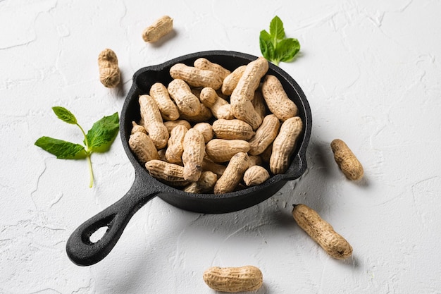 Nueces de maní enteras sobre fondo de mesa de piedra blanca