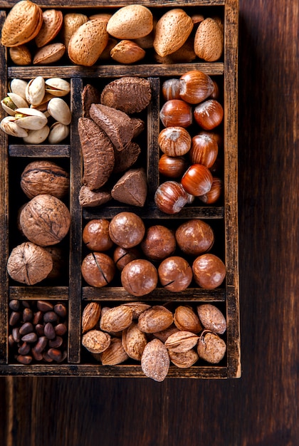 Foto nueces mezcladas en una caja de madera de la vendimia. surtido