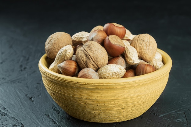 Nueces mixtas con cáscara en un tazón de cerca