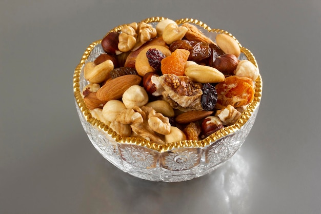 Nueces mixtas en un plato de vidrio Nutrición saludable y natural Anacardo Almendra Avellana Higo Nuez Albaricoque Pasas Arándano