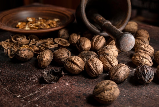 Nueces y mortero metálico sobre un fondo de madera