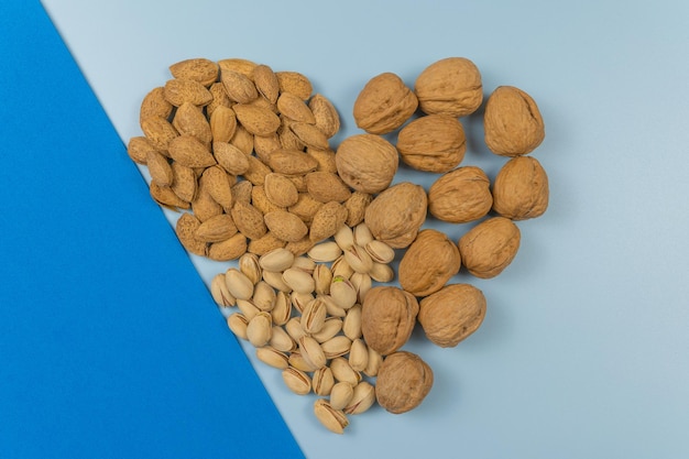 nueces naturales y saludables con forma de corazón y fondo azul