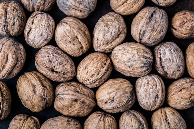 Nueces Nueces y nueces enteras en la mesa rústica.