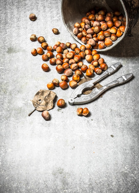 Nueces en la olla vieja sobre la mesa de piedra