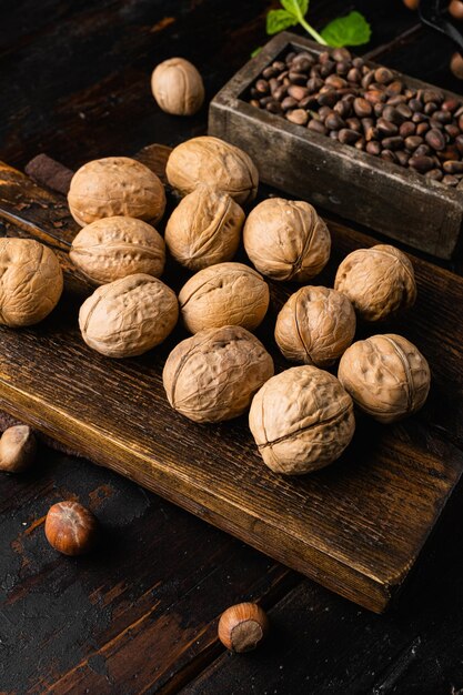 Nueces orgánicas enteras colocadas sobre un viejo fondo de mesa de madera oscura