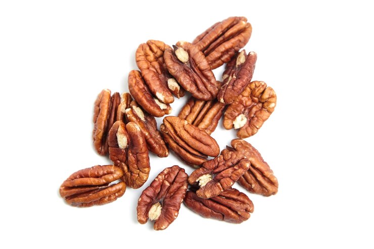 Nueces de pacana peladas aisladas en una vista superior de fondo blanco Montón de mitades de pacana