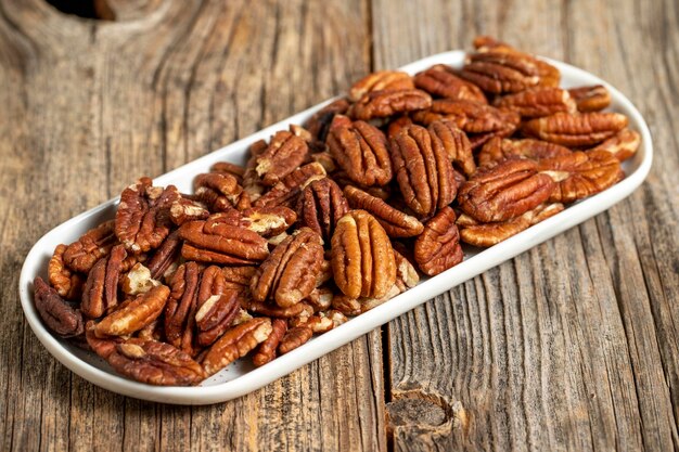 Foto nueces de pecan en fondo de madera de cerca