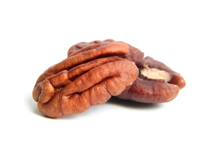 Nueces pecanas peladas aisladas sobre un fondo blanco Montón de mitades de pecanas