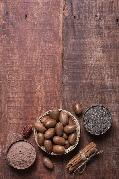 Nueces pecanas, semillas de chia y cacao en tazones sobre una mesa de madera