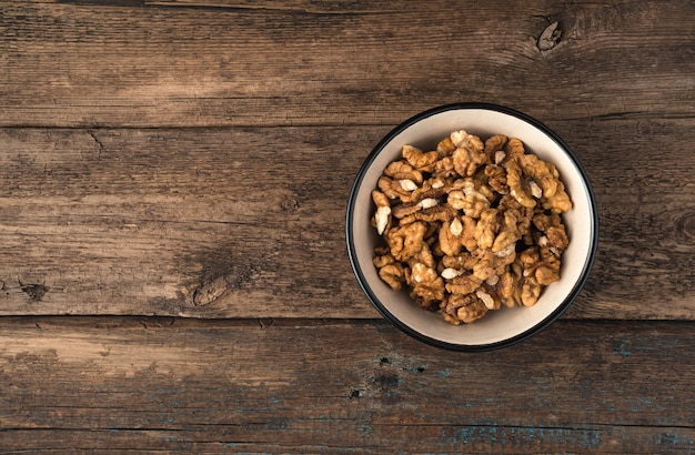 Nueces peladas en un recipiente sobre una superficie de madera