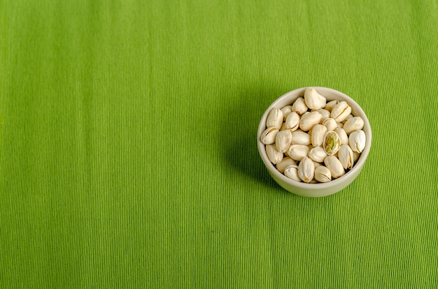 Nueces de pistacho en fondo verde del paño de tabla