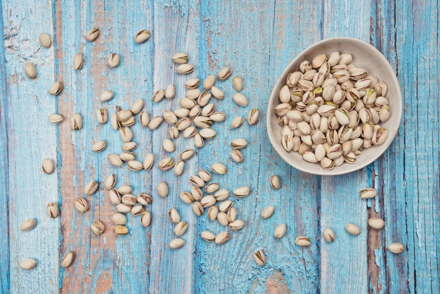 Nueces de pistacho en mesa de madera antigua azul