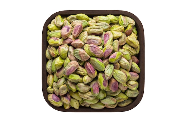 Nueces de pistachos peladas en un recipiente cuadrado aislado sobre fondo blanco. alimentos orgánicos, vista superior.