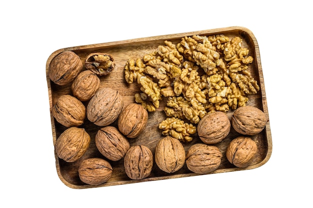 Nueces en un plato de madera y granos de nuez aislado sobre fondo blanco.