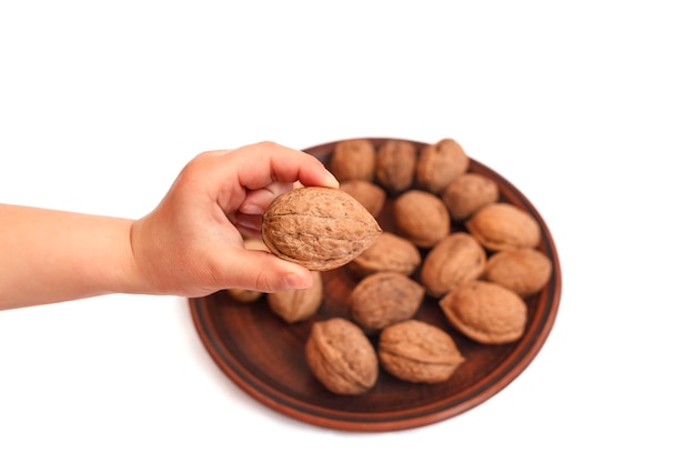 Nueces en un plato en manos de los niños