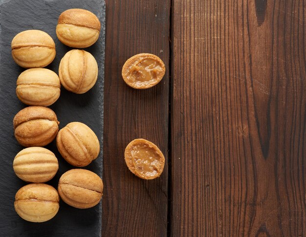 Nueces de postre horneadas con leche condensada en la vista superior del tablero de pizarra negra