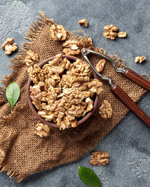 Nueces en un recipiente de arcilla. Nueces y cascanueces en gris